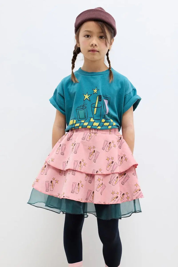 Niña vestida con falda rosa y camiseta verde oscuro a juego de Weekend House Kids.