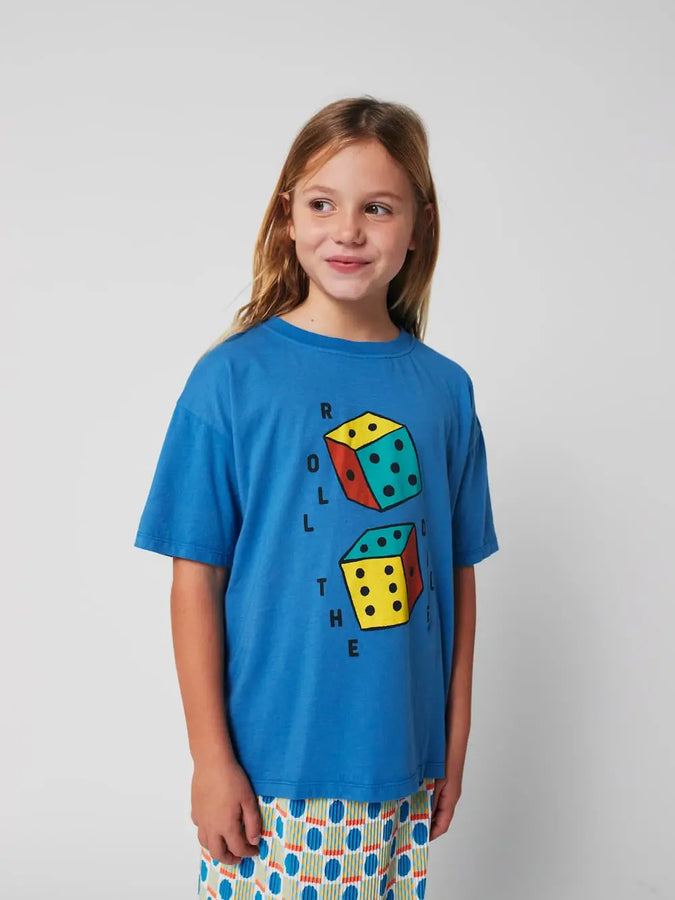 Niña vistiendo camiseta azul con dibujo de de dados multicolores de Bobo Choses.