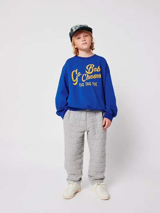 Niño con sudadera azul Go Bobo Choses y pantalon de chandal gris, Bobo Choses aw25.