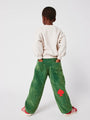 Niño con pantalones verdes de pana y sudadera blanco roto de Bobo Choses.