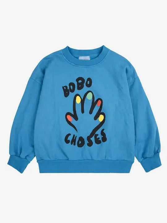 Sudadera azul con dibujo de mano con uñas multicolores y logo de Bobo Choses, vista delantera.