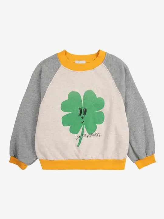 Sudadera crema con mangas grises y dibujo de trébol de Bobo Choses para niñas y niños.