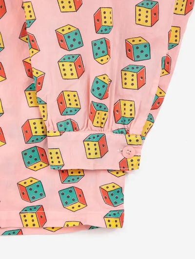 Detalle de puño de la manga de camisa rosa con estampado de dados multicolores.
