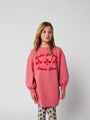 Niña con vestido rosa con letras rojas Have Fun de Bobo Choses.