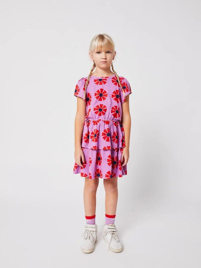 Niña, vista delantera, vistiendo vestido morado de manga corta de caleidoscopios de Bobo Choses.