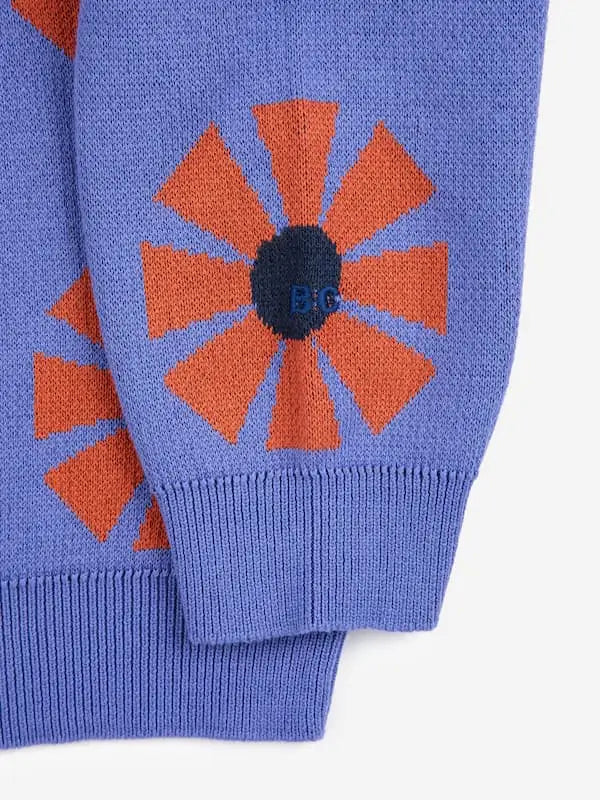 Detalle de logo de BC bordado en hilo, en una manga del jersey morado con estampado de caleidoscopios rojos para niñas y niños de Bobo Choses.