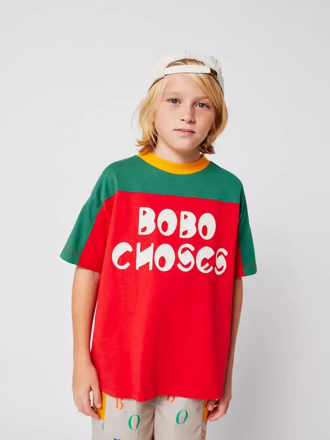 Niño vistiendo camiseta roja color block con mangas cortas de Bobo Choses.
