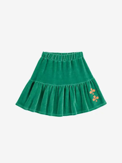 Falda corta verde de terciopelo para niñas de Bobo Choses. Tiene cintura elástica y volante con dos tréboles bordados en hilo de color tierra.