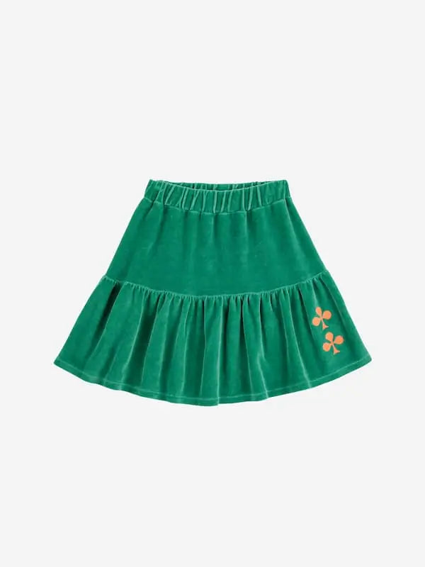 Falda corta verde de terciopelo para niñas de Bobo Choses. Tiene cintura elástica y volante con dos tréboles bordados en hilo de color naranja.