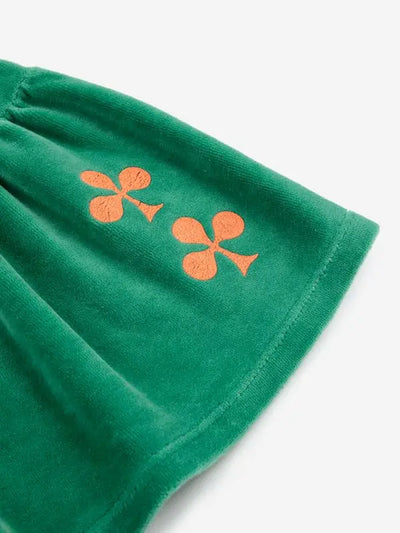 Detalle de tréboles bordados en color tierra en parte inferior izquierda en la falda corta verde de terciopelo para niñas de Bobo Choses. 