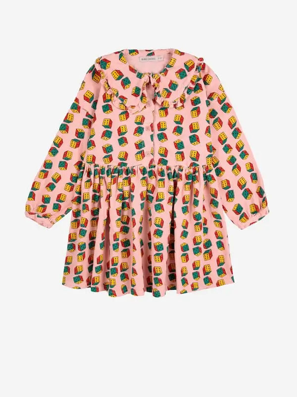Vestido rosa de micro pana con estampado de dados multicolor. Tiene cuello de Peter Pan y goma en la cintura.