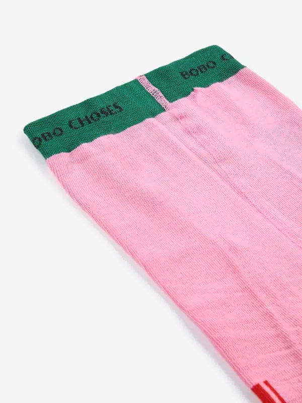 Detalle de la goma de cintura en color verde con el logotipo de Bobo Choses en la parte superior de los leotardos rosas.