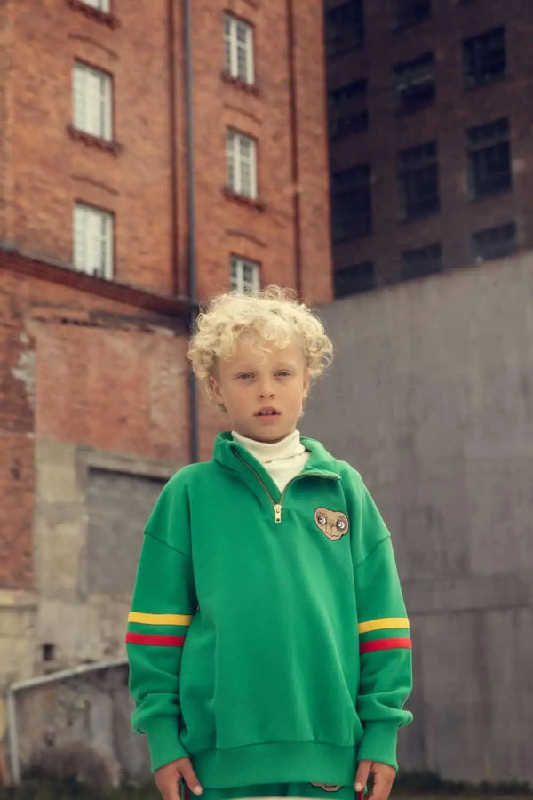 Niño con sudadera verde de colección  cápsula E.T. de Mini Rodini moda infantil sostenible.