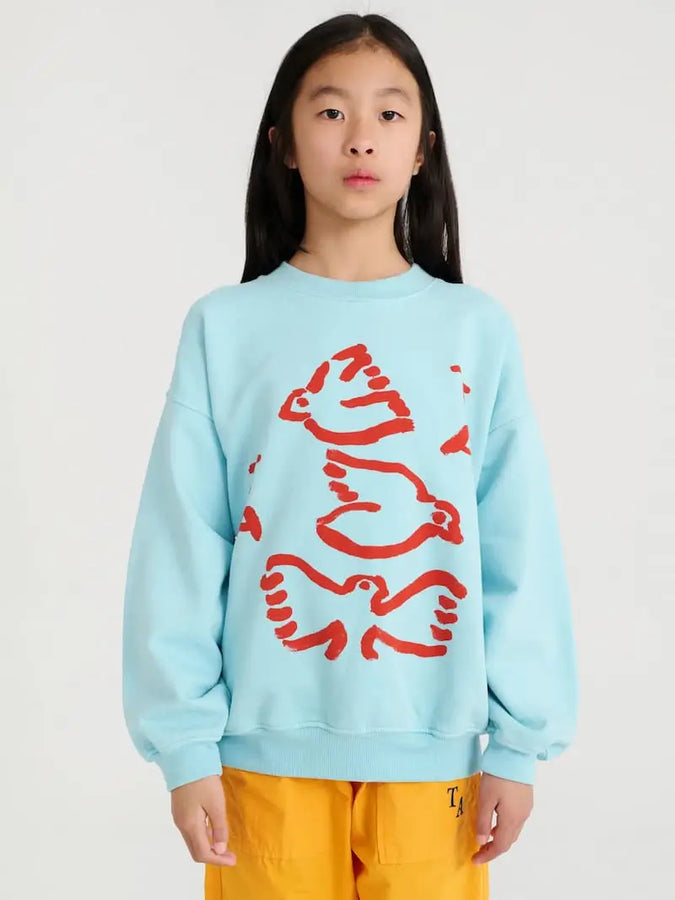 Modelo infantil con la sudadera nº 07 Blue Glow True Artist azul celeste con estampado rojo de aves.