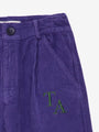 Detalle de bolsillo de pantalon morado de pana con logo de True Artist, moda infantil  sostenible.