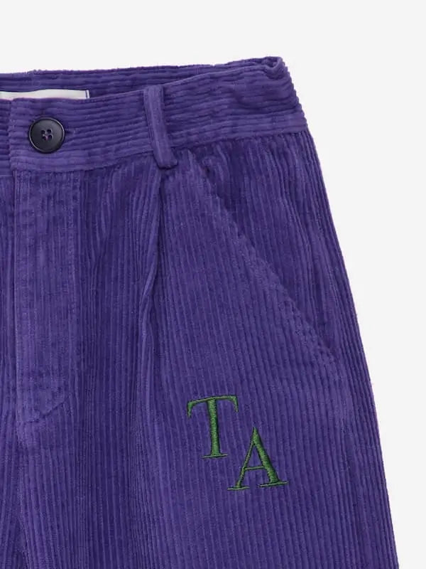 Detalle de bolsillo de pantalon morado de pana con logo de True Artist, moda infantil  sostenible.