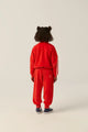 Vista atras de niña con conjunto rojo de terciopelo, sudadera y pantalon chandal, de The Campamento.