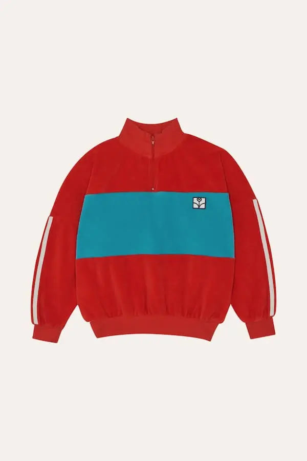 Sudadera roja te terciopelo con detalle de color azul en el pecho y rayas blancas en las mangas de The Campamento.