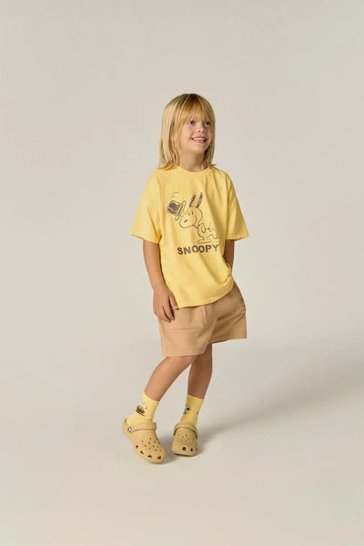 Niño con camiseta amarilla con Snoopy de The Campamento