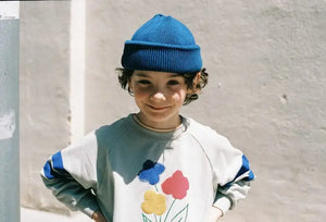 Niño con sudadera gris claro y dibujo de flores de Weekend House Kids para niños y niñas.