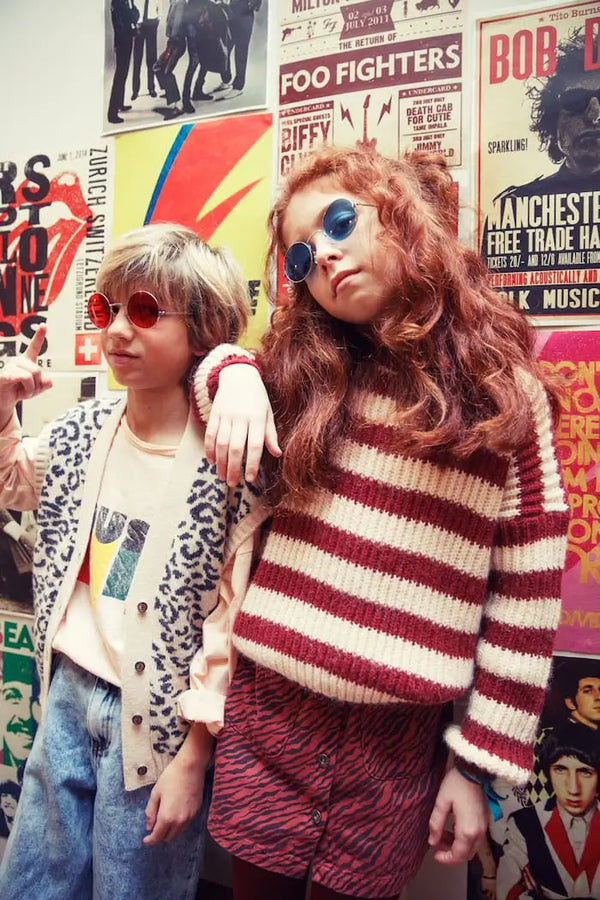 Niña con jersey de rayas crudo & burdeos y falda animal print, niño con vaquero unisex azul, camiseta rosa con texto Music y chaleco animal print. Todo de Piupiuchick, coleccion de otoño I´m with the band.