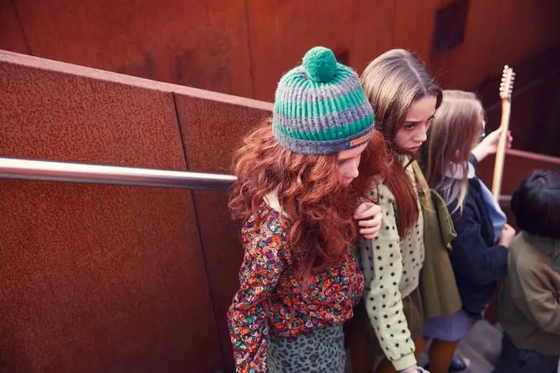 Niña con blusa infantil con cuello Peter Pan y estampado multicolor de flores, colección Piupiuchick otoño invierno 2025.