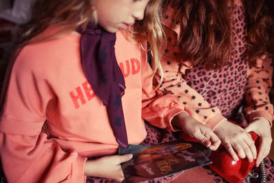 Niñas con prendas de Piupiuchick, una con sudadera  rosa con texto en el pecho "Hey Jude", otra con peto rosa de pana con animal print, todo de Piupiuchick.