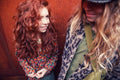 Dos niñas con ropa de la colección Piupiuchick otoño/invierno; una lleva blusa floral multicolor y la otra camisa de cuadros con abrigo estampado animal print.