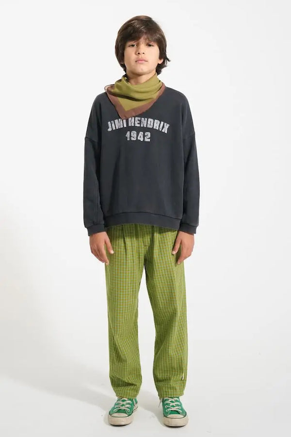 Niño con pantalones verdes de cuadros pequeños, sudadera negra lavada y pañuelo verde oliva de Piupiuchick 