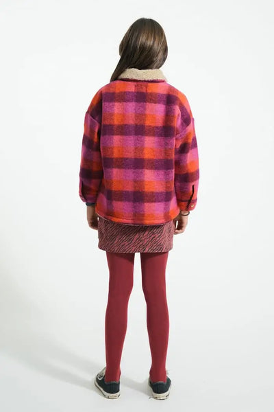 Niña con falda corta buerdeos y chaqueta multicolor de Piupiuchick-vista trasera.