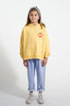 Niña con vaqueros azules y sudadera con capucha de color amarillo claro de Piupiuchick.