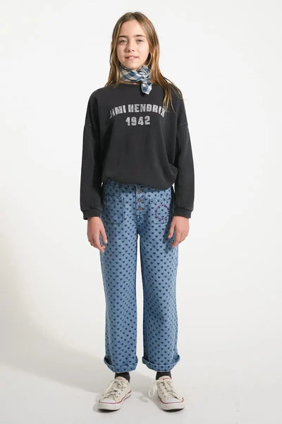 Niña con pantalón acampanado de corazones y sudadera negra de Piupiuchick.