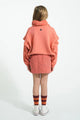 Vista trasera de niña con falda rosa mini de flores y sudadera rosa " Groupie" de Piupiuchick.