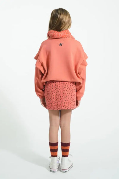 Vista trasera de niña con falda rosa mini de flores y sudadera rosa " Groupie" de Piupiuchick.