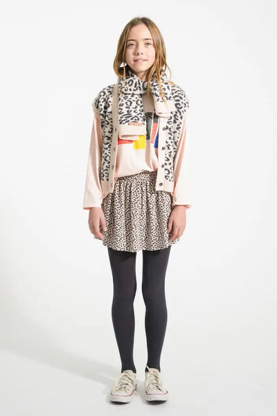 Niña con falda de rosa claro de animal print, chaleco de animal print, camiseta rosa y bufanda de animal print, todo de Piupiuchick.