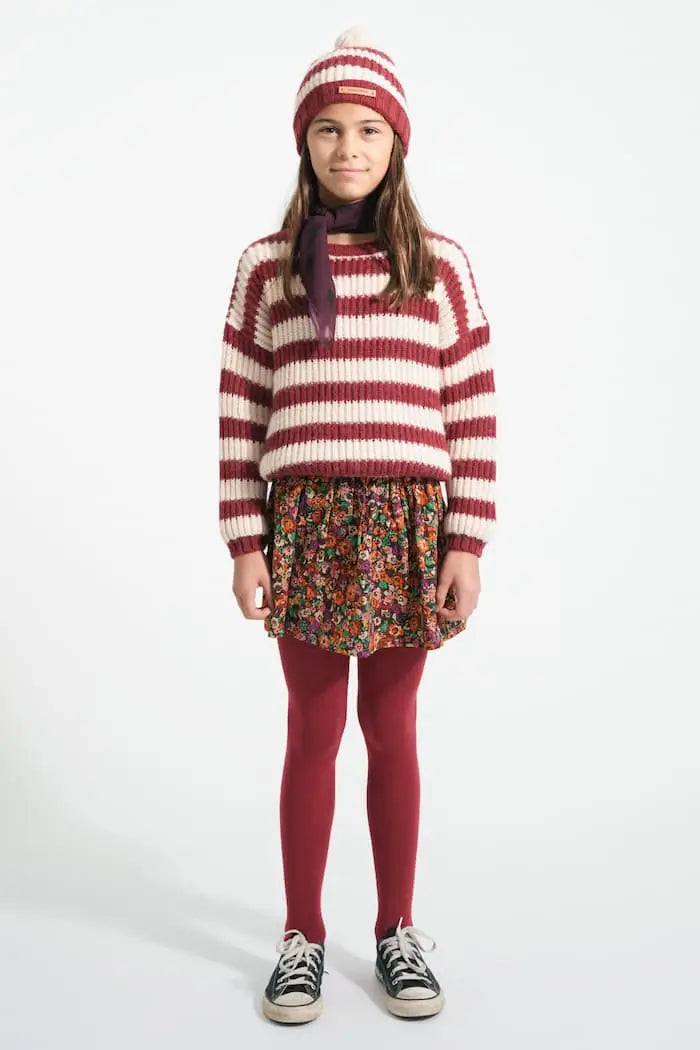 Niña con falda corta de flores, jersey de rayas y gorro crudo de rayas Piupiuchick 