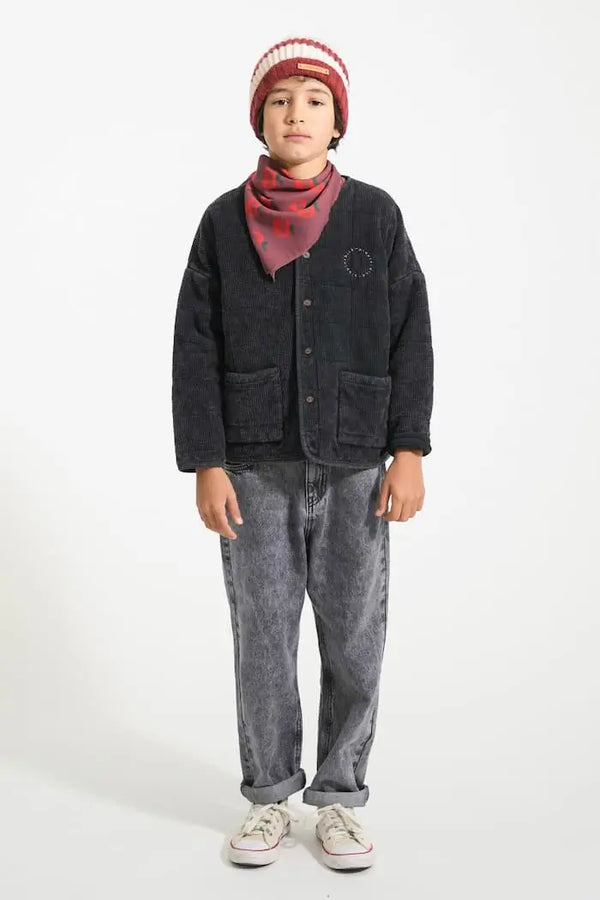 Niño con vaqueros unisex negros, chaqueta negra y gorro de rayas crudas y burdeos de Piupiuchick coleccion otoño invierno 2025