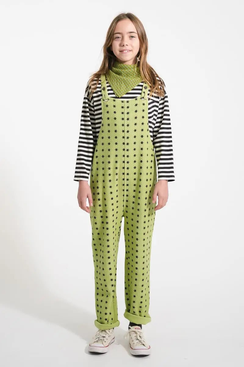 Niña vistiendo el peto verde pistacho con estampado de estrellas y camiseta de rayas, todo de Piupiuchick de la colección AW25.