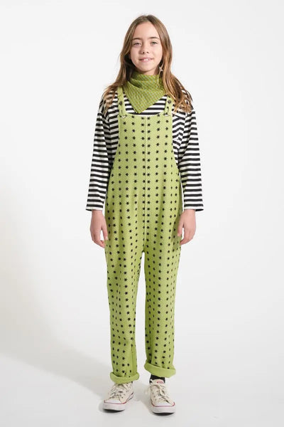 Niña vistiendo el peto verde pistacho con estampado de estrellas y camiseta de rayas, todo de Piupiuchick de la colección AW25.