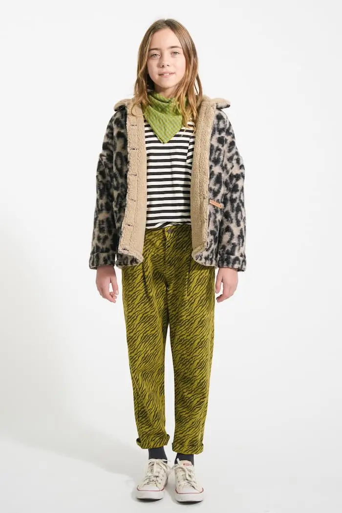 Niña vistiendo camiseta Piupiuchick con rayas negras sobre fondo blanco y de manga larga bajo una chaqueta con estampado de animal print - parte delantera