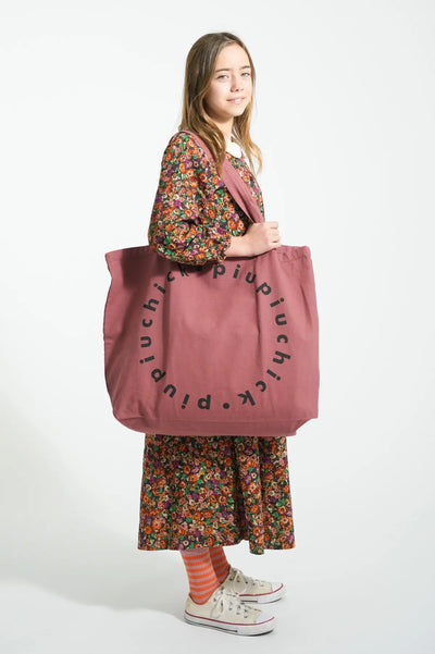 Niña con vestido largo de flores con bolsa XL con logo de Piupiuchick