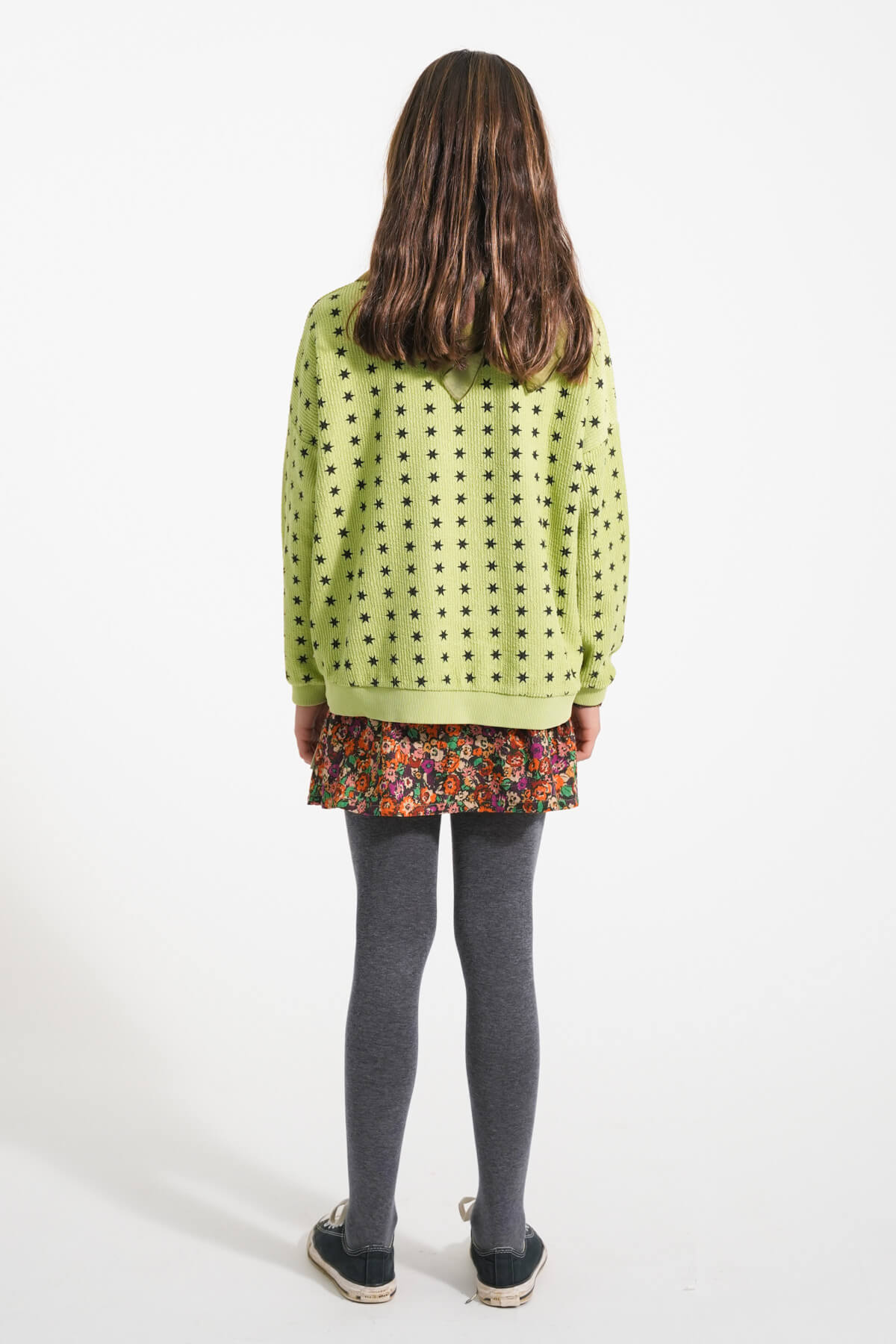 Vista atras de niña con sudadera verde de estrellas y falda de flores de Piupiuchick
