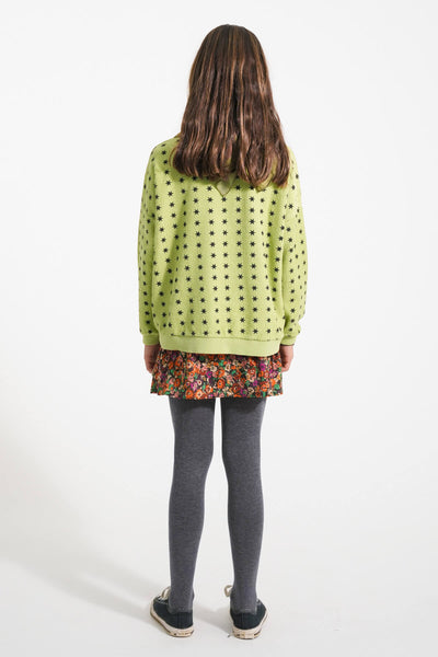 Vista atras de niña con sudadera verde de estrellas y falda de flores de Piupiuchick