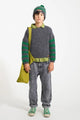 Niño con vaquero negro unisex, camisa verde, jersey gris con rayas verdes en las mangas, colección de Piupiuchick para otoño AW25.