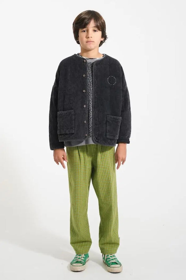 Niño con pantalón verde de cuadros, sudadera gris con animal print y chaqueta acolchada de Piupiuchick.