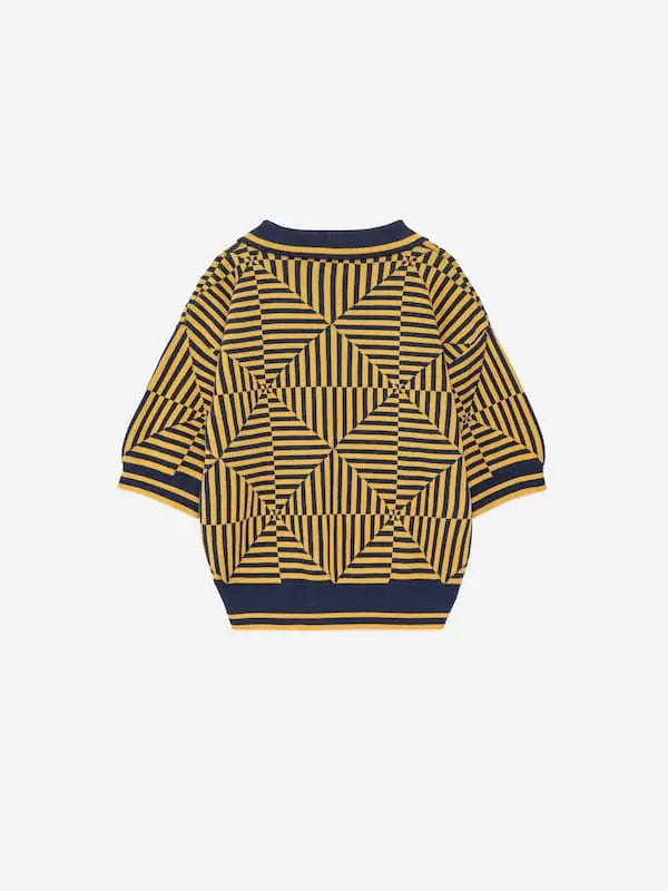 Vista atrás del polo azul marino con manga corta  y estampado de caleidoscopios de color amarillo.